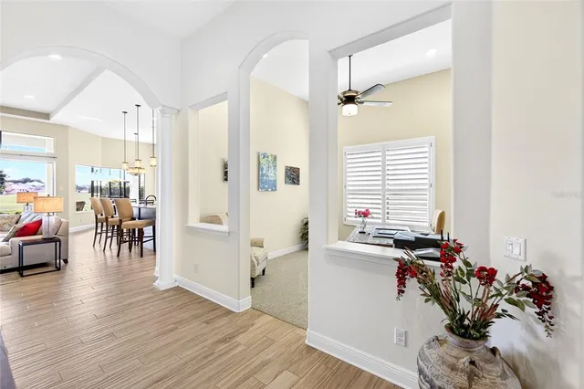 a living room with furniture a flat screen tv and kitchen view
