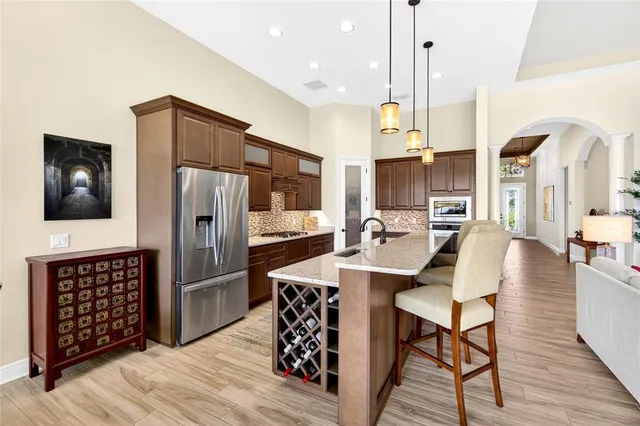 a dining room with wooden floor a chandelier a wooden table and chairs