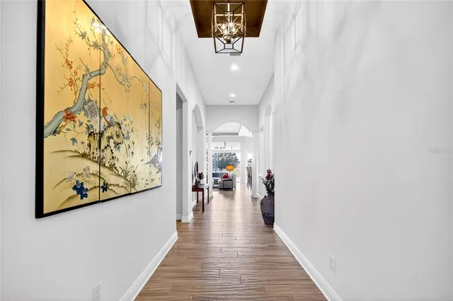 a view of a hallway with wooden floor and stairs