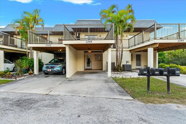 a front view of a building with a garden and plants