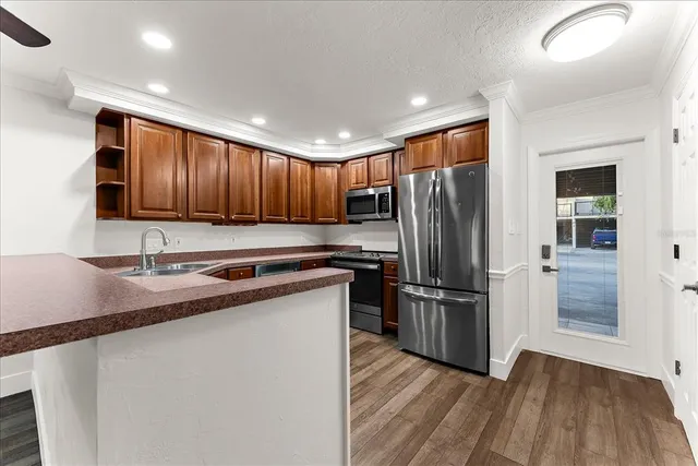a kitchen with stainless steel appliances granite countertop wooden cabinets a sink and a stove