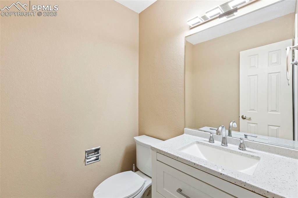 4315 Hunting Meadows Circle, Unit 1 Colorado Springs, CO 80916 - Photo 11 of 26 a bathroom with a toilet sink vanity and mirror