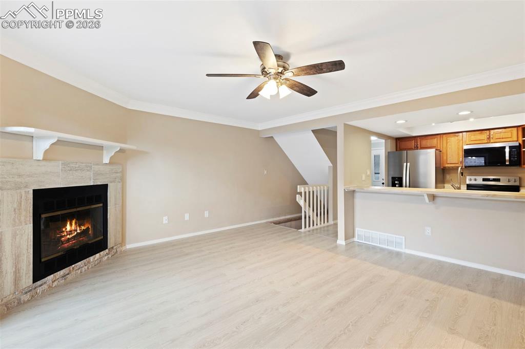4315 Hunting Meadows Circle, Unit 1 Colorado Springs, CO 80916 - Photo 6 of 26 a view of a livingroom with a fireplace a ceiling fan and a kitchen view