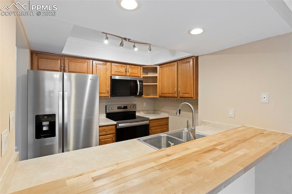 4315 Hunting Meadows Circle, Unit 1 Colorado Springs, CO 80916 - Photo 8 of 26 a kitchen with granite countertop a refrigerator and a sink