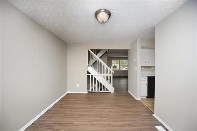 a hallway with wooden floor table and chairs