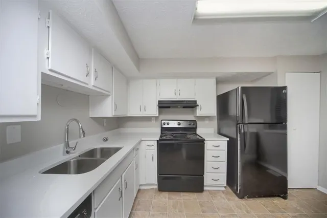 a kitchen with stainless steel appliances a refrigerator sink and cabinets