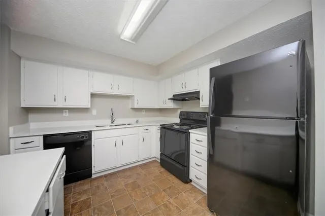 a kitchen with a sink stove and refrigerator