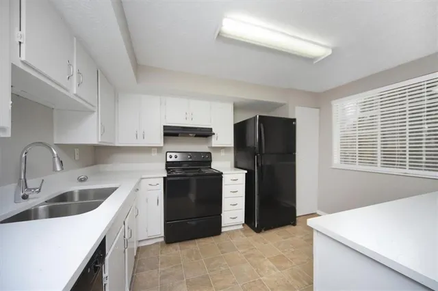 a kitchen with stainless steel appliances granite countertop a refrigerator sink and stove