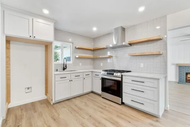 a kitchen with granite countertop white cabinets and stainless steel appliances