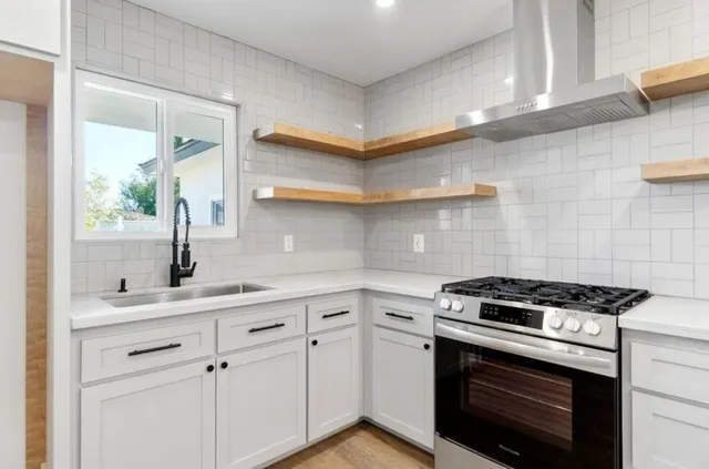 a kitchen with white cabinets and appliances