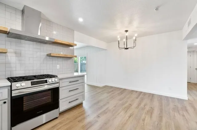 a kitchen with a stove and a wooden floor