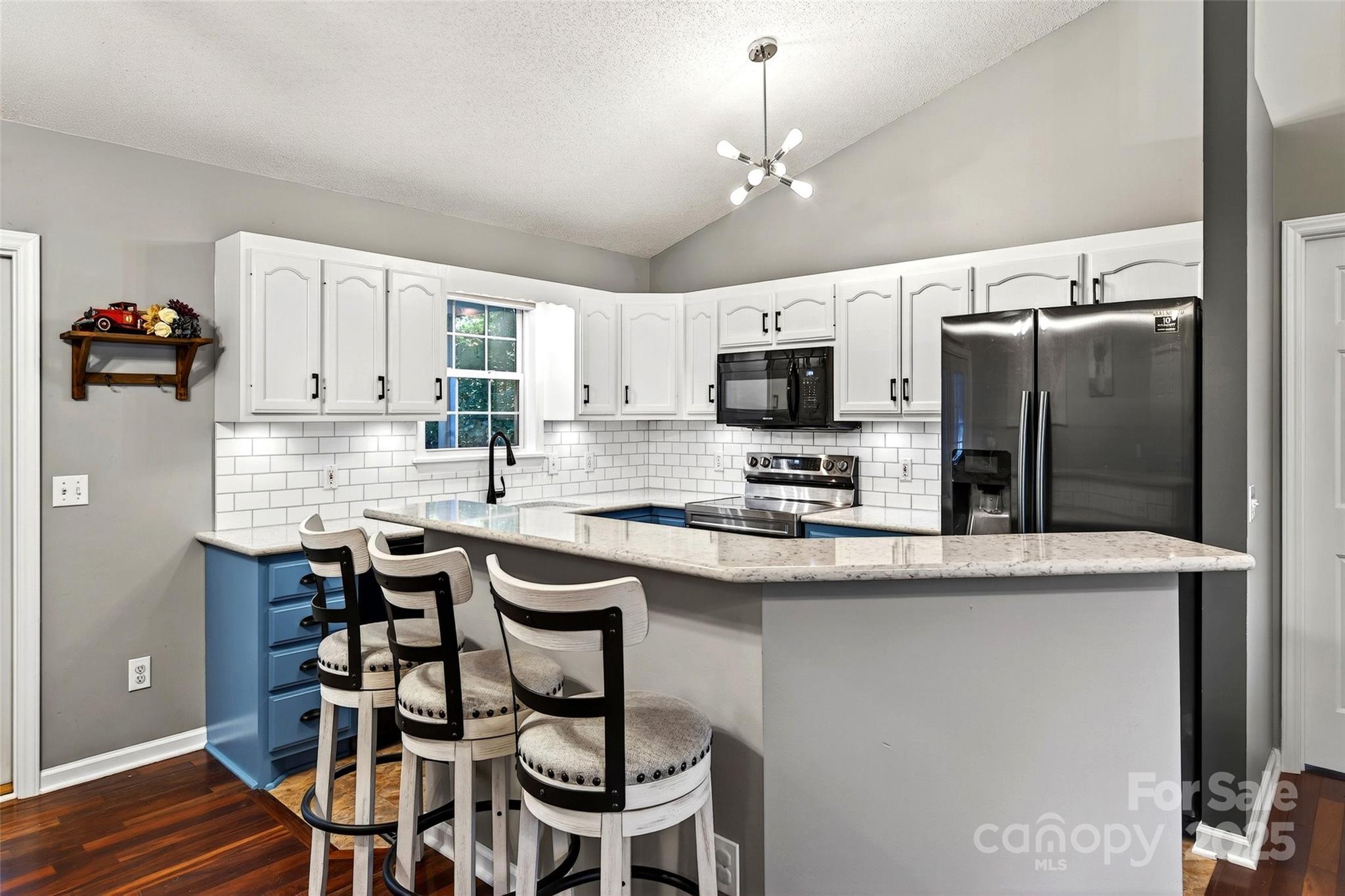 2691 Laurel Point Drive Nebo, NC 28761 - Photo 6 of 44 a kitchen with kitchen island granite countertop a table chairs microwave and cabinets