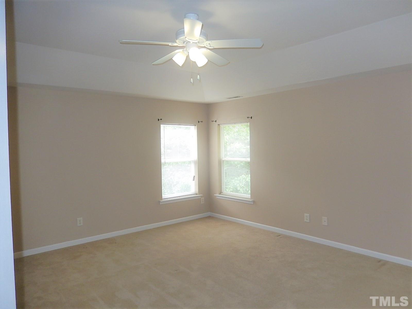 101 Olvera Way Holly Springs, NC 27540 - Photo 16 of 25 an empty room with windows and ceiling fan