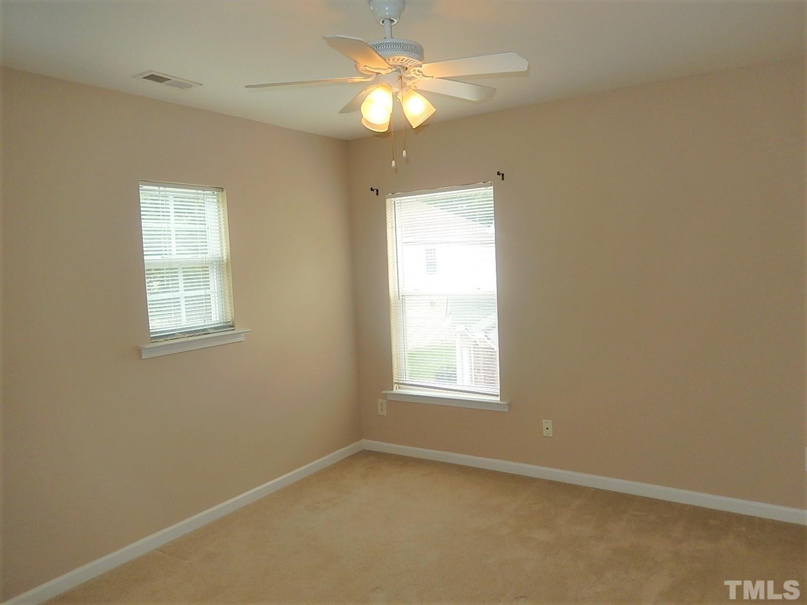 101 Olvera Way Holly Springs, NC 27540 - Photo 22 of 25 an empty room with a window and a fan