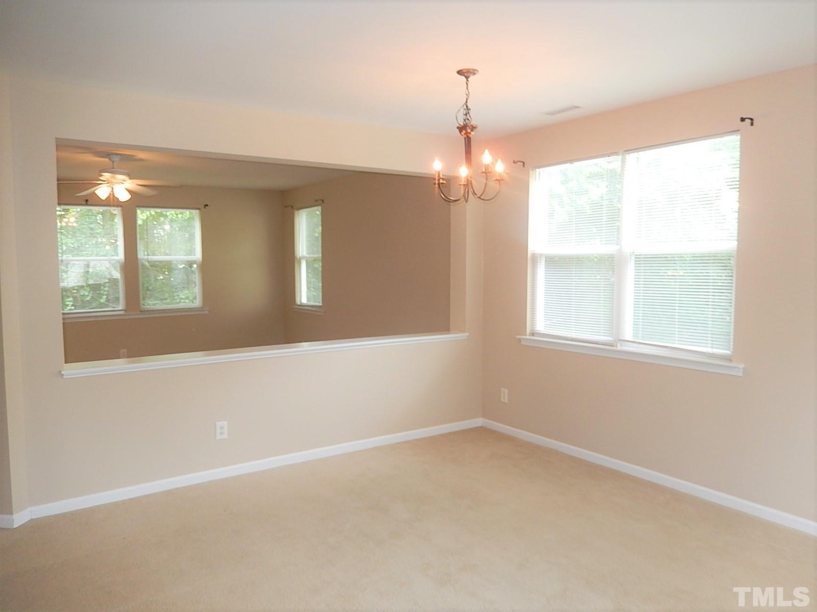 101 Olvera Way Holly Springs, NC 27540 - Photo 3 of 25 an empty room with a empty space and windows