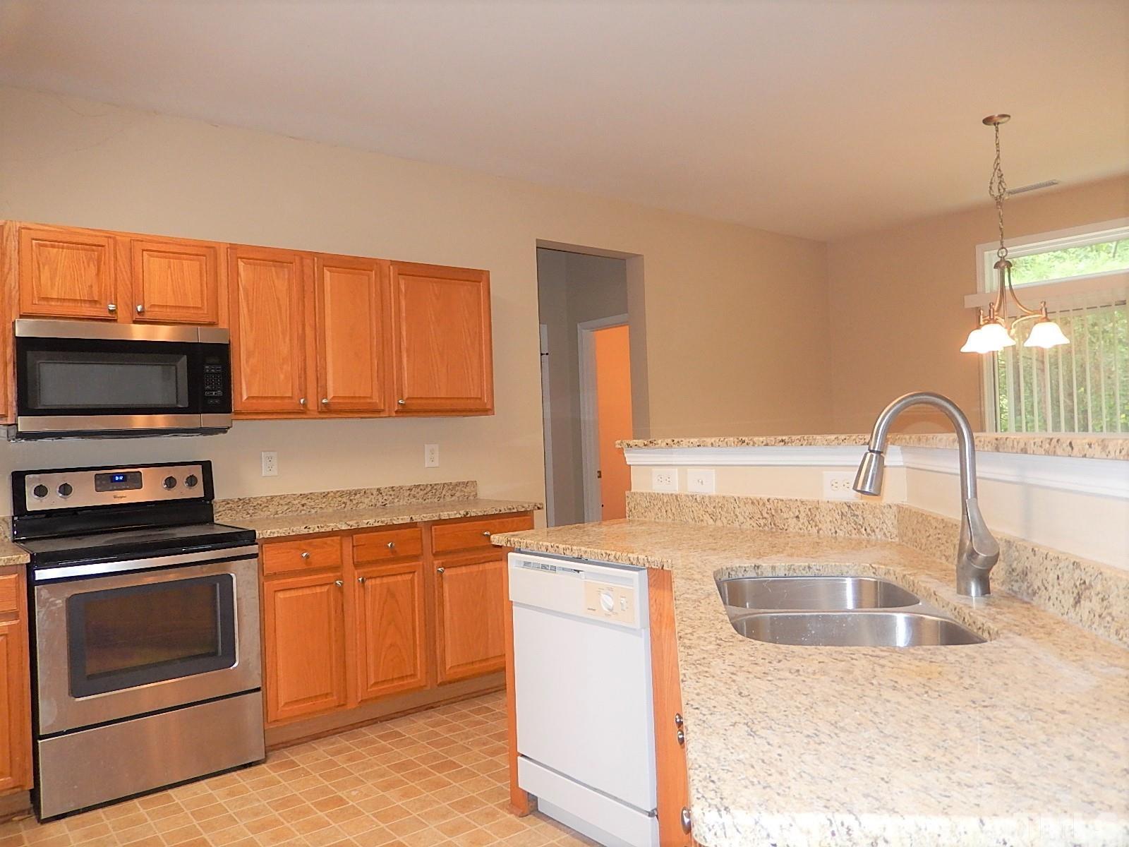 101 Olvera Way Holly Springs, NC 27540 - Photo 9 of 25 a kitchen with a sink stove and microwave