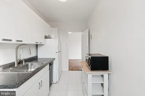 a kitchen with stainless steel appliances granite countertop a sink a microwave refrigerator and a counter top space