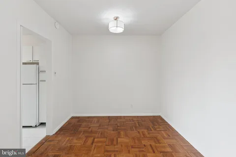 a view of a room with wooden floor and a ceiling fan