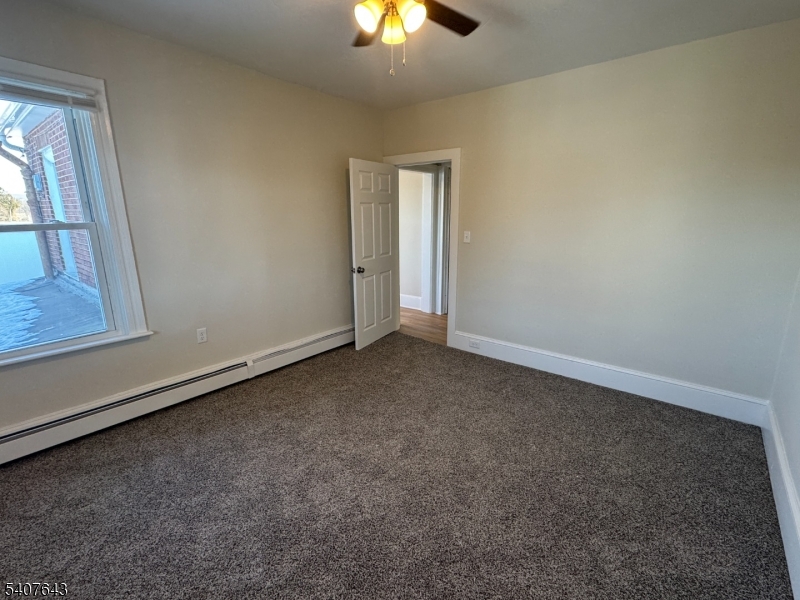 27 Filmore Street Phillipsburg, NJ 08865 - Photo 6 of 15 an empty room with a chandelier fan and windows