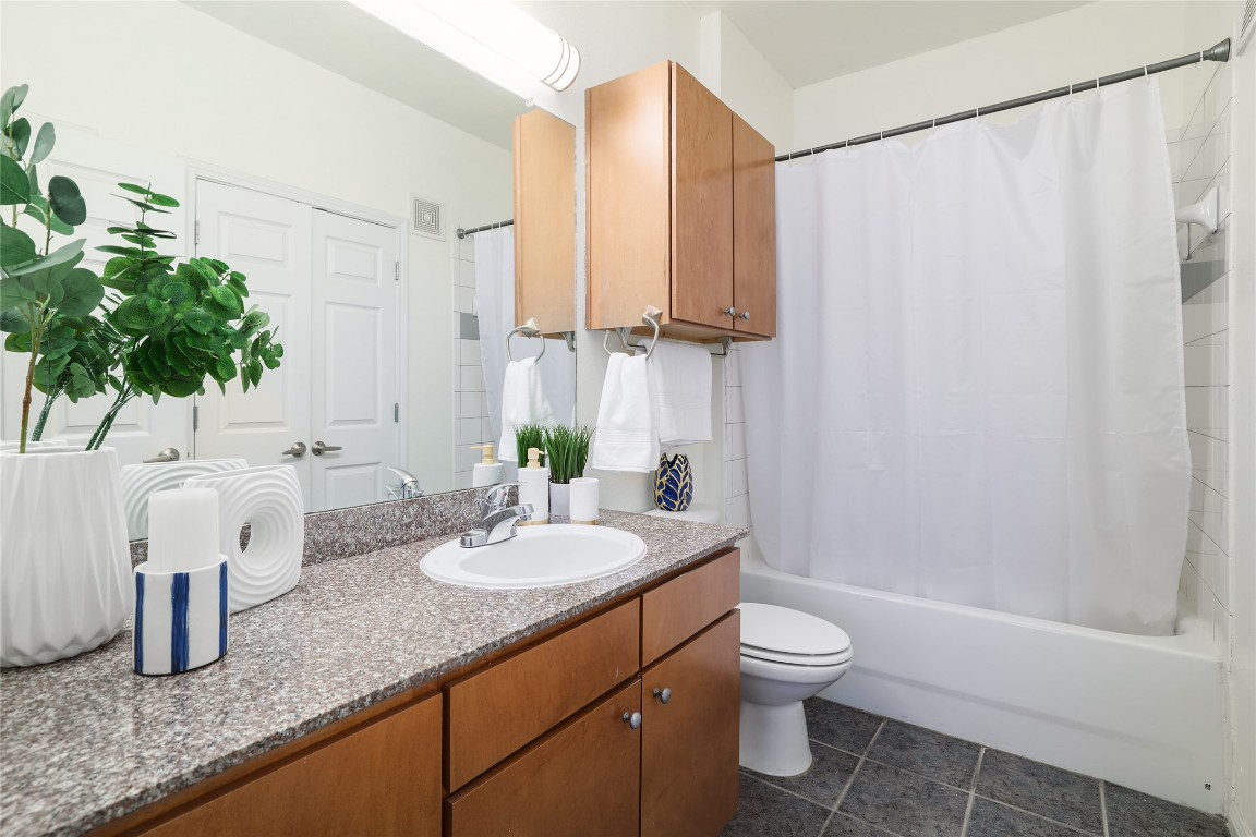 2502 Leon Street, Unit 208 Austin, TX 78705 - Photo 14 of 19 a bathroom with a granite countertop sink a toilet and shower