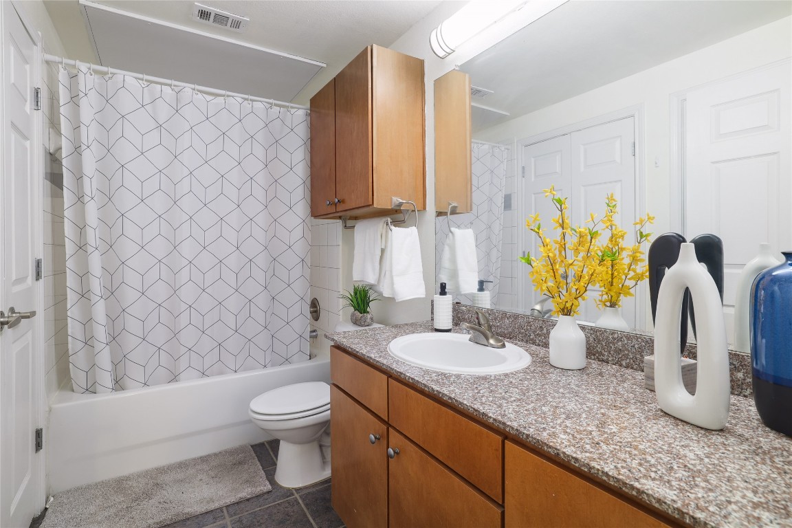 2502 Leon Street, Unit 208 Austin, TX 78705 - Photo 18 of 19 a bathroom with a granite countertop bathtub sink vanity mirror and toilet