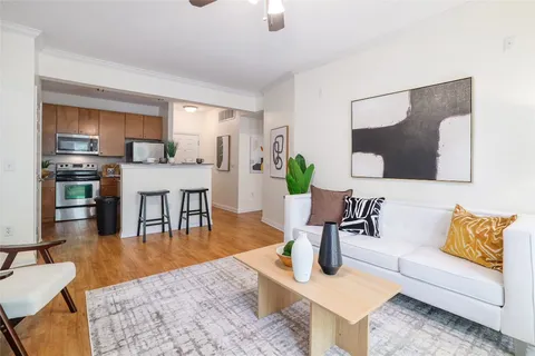 a kitchen with stainless steel appliances granite countertop a refrigerator a stove a sink dishwasher and white cabinets with wooden floor