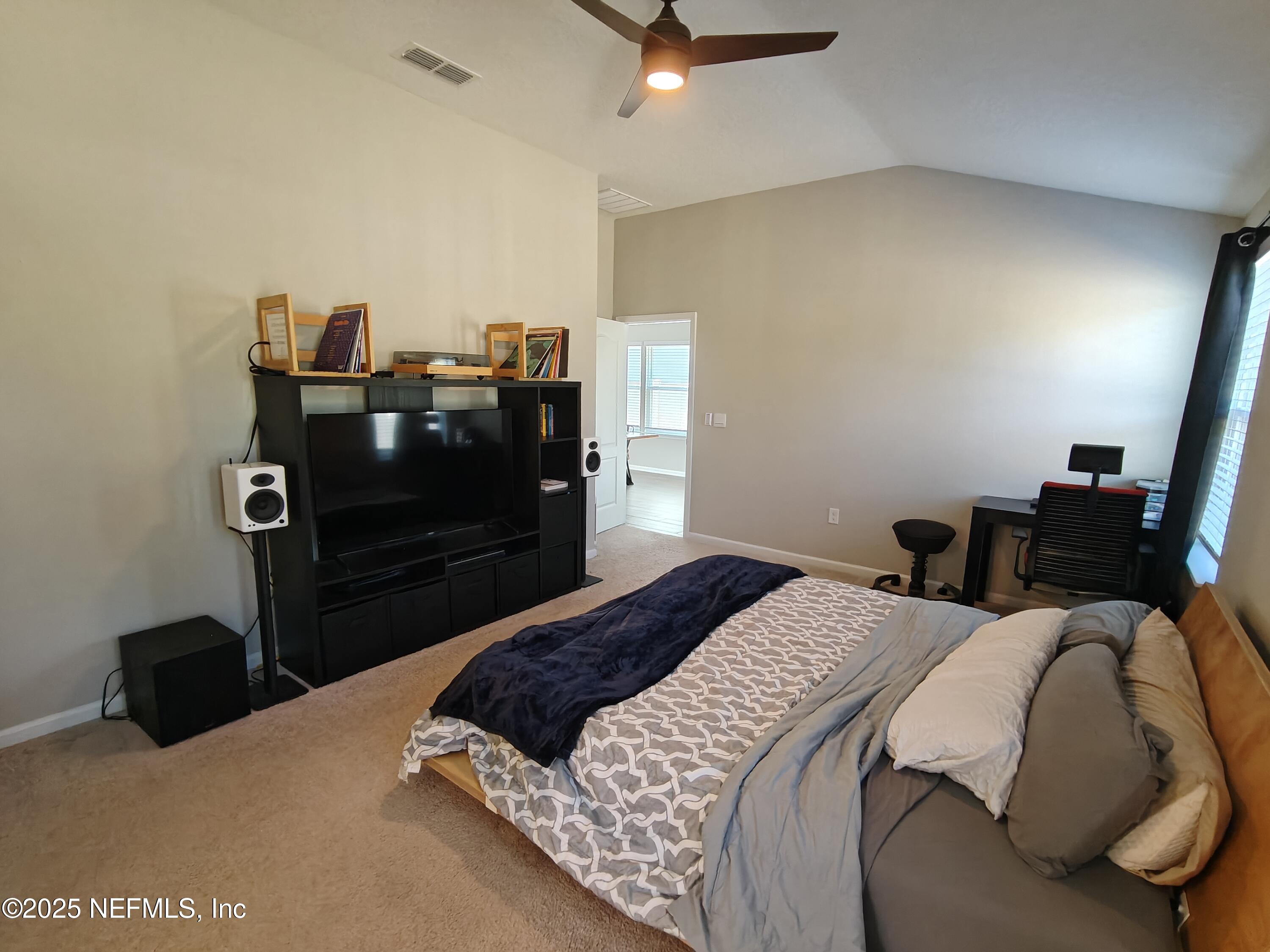 70481 Winding River Drive Yulee, FL 32097 - Photo 30 of 53 a bedroom with a bed and a television