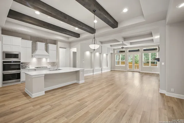 a large kitchen with lots of counter space a sink and stainless steel appliances