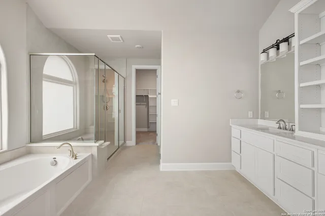 a spacious bathroom with a bathtub sink and mirror