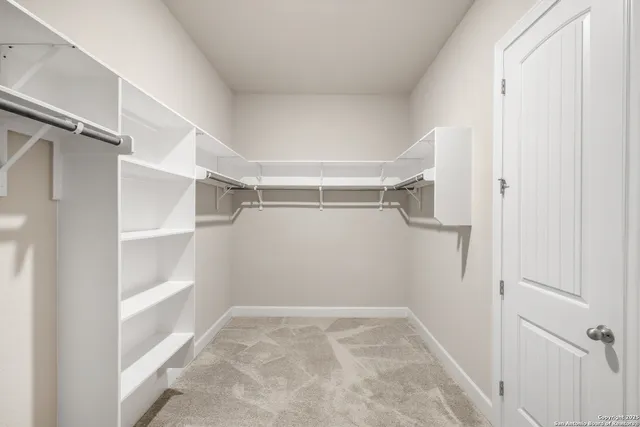 a view of walk in closet with empty racks