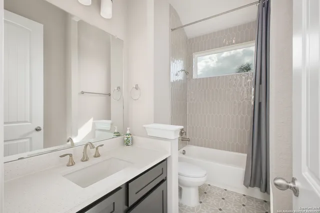 a bathroom with a sink a toilet a tub and shower