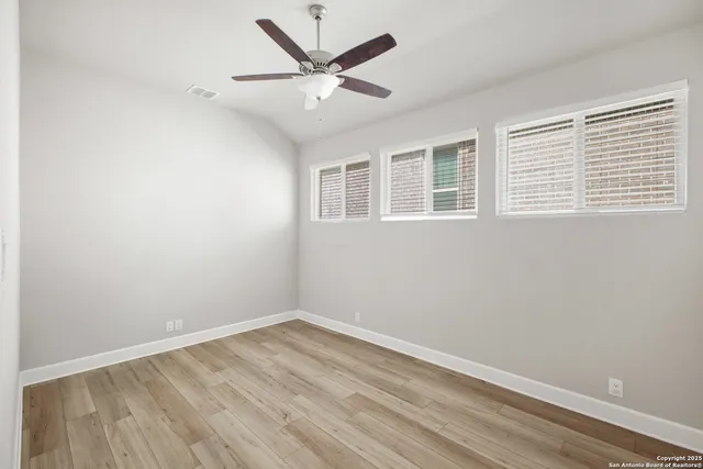 a view of a big room with wooden floor and windows