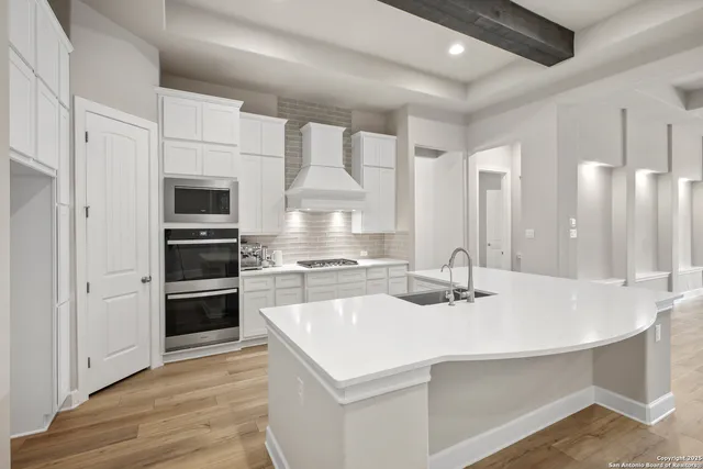 a kitchen with kitchen island a sink appliances and cabinets