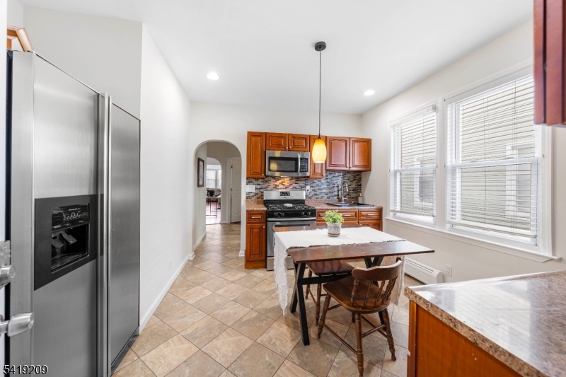 752 Eaton Street Elizabeth, NJ 07202 - Photo 13 of 27 a kitchen with stainless steel appliances granite countertop a refrigerator a sink a stove and a wooden floors