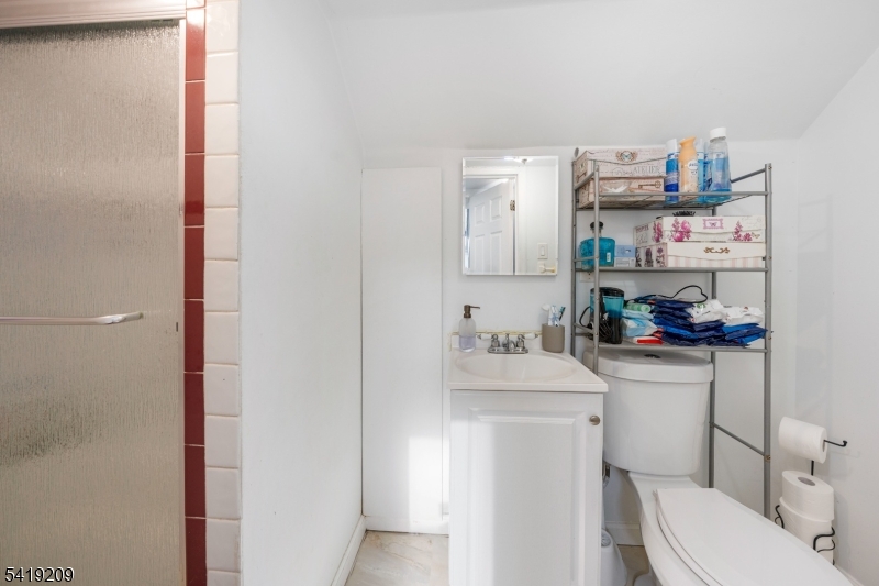 752 Eaton Street Elizabeth, NJ 07202 - Photo 20 of 27 a bathroom with a sink a toilet and a shower curtain
