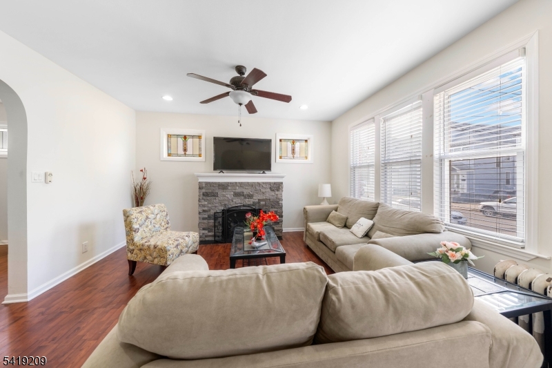 752 Eaton Street Elizabeth, NJ 07202 - Photo 6 of 27 a living room with furniture a fireplace and a flat screen tv