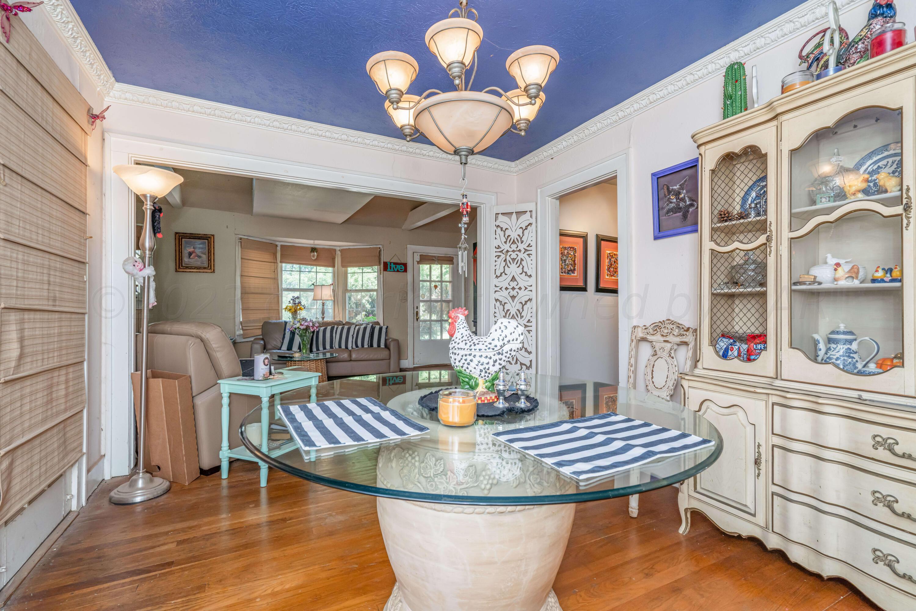 4809 Arden Road Amarillo, TX 79110 - Photo 13 of 34 a dining room with furniture a wooden floor and chandelier