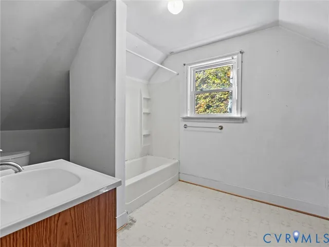 a bathroom with a tub sink and mirror