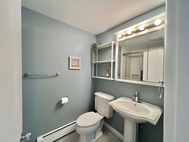 a bathroom with a sink mirror and toilet