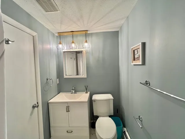 a bathroom with a toilet a sink and mirror