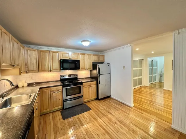a kitchen with stainless steel appliances granite countertop a sink and wooden cabinets