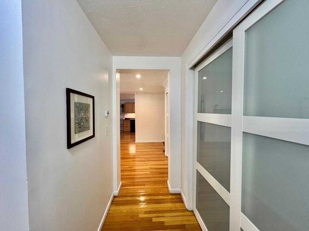 95 Maple Street, Unit 18 Malden, MA 02148 - Photo 9 of 24 a hallway with wooden floor
