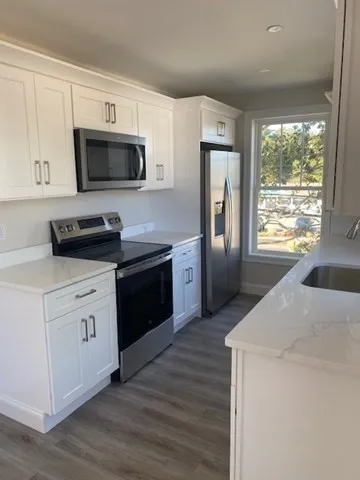 a kitchen with a stove a sink and a microwave