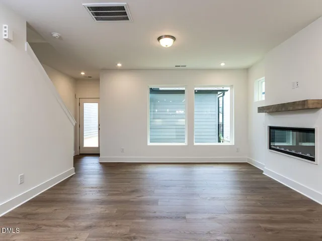 an empty room with wooden floor and fireplace