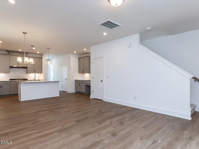 a view of kitchen with kitchen island a sink wooden floor and a refrigerator
