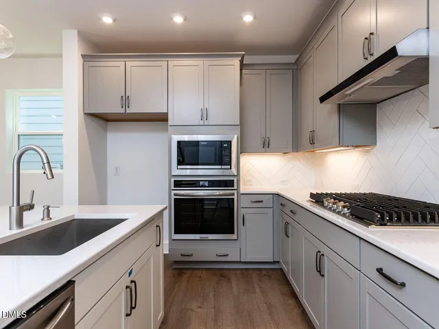 a kitchen with granite countertop a sink stove and cabinets