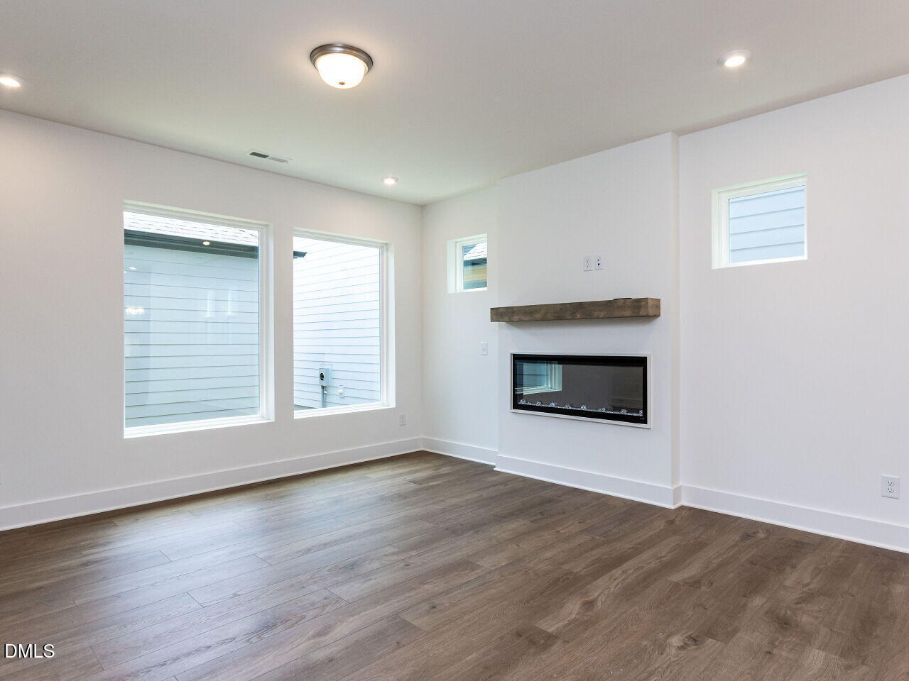 7 Tallgrass Road Pittsboro, NC 27312 - Photo 10 of 32 an empty room with wooden floor fireplace and windows