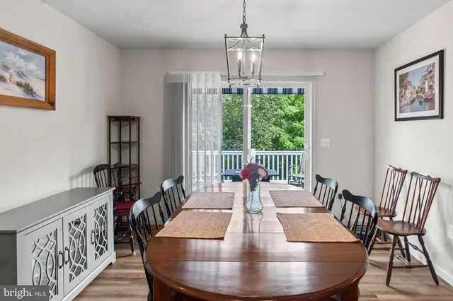 a view of a dining room with furniture a chandelier and wooden floor