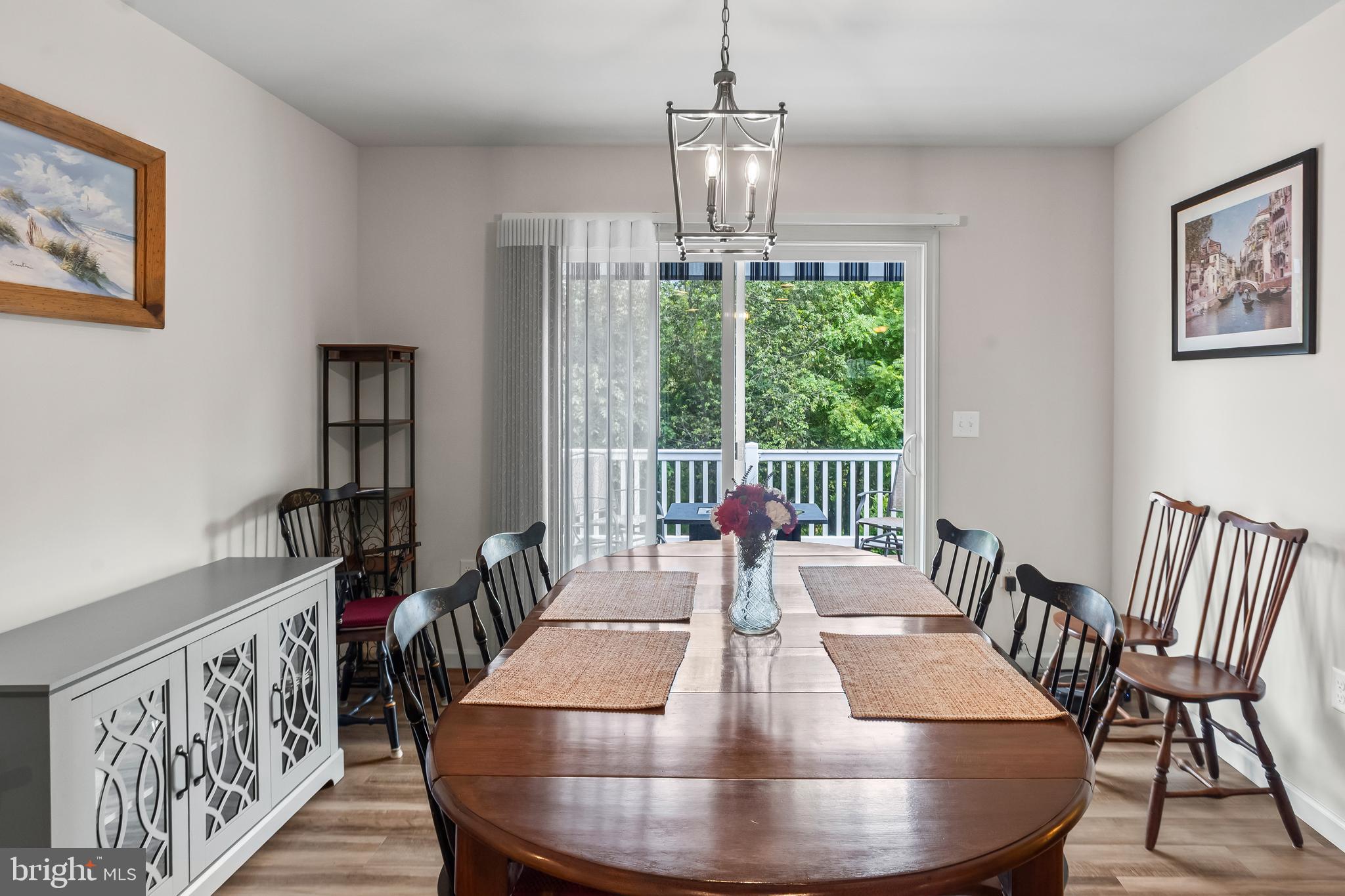 2069 Spring Wood Lane Mechanicsburg, PA 17055 - Photo 18 of 41 a view of a dining room with furniture a chandelier and wooden floor