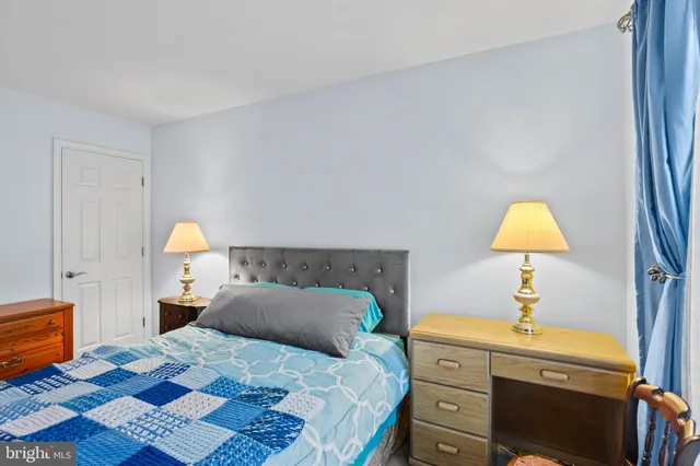 a bedroom with a bed and a lamp on dresser